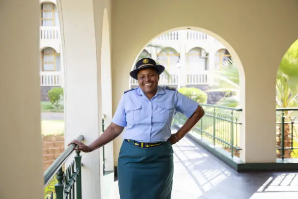 An officer in uniform standing on a balcony, looking out at the scenery.