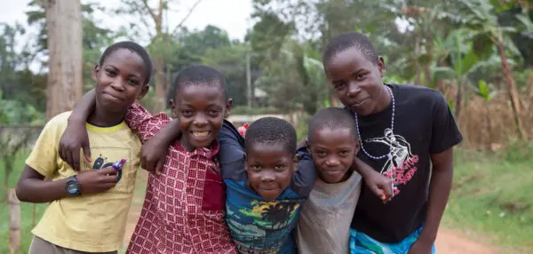 five boys with their arms around shoulders looking into the camera