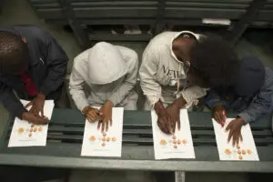 four people drawing their own hands