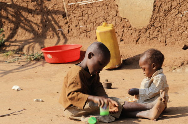Two children sitting on the ground playing