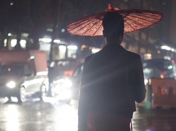 a person under a red umbrella at night in a street