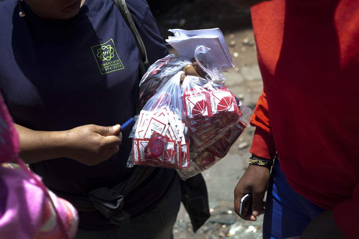 Woman handing out condoms to sex workers