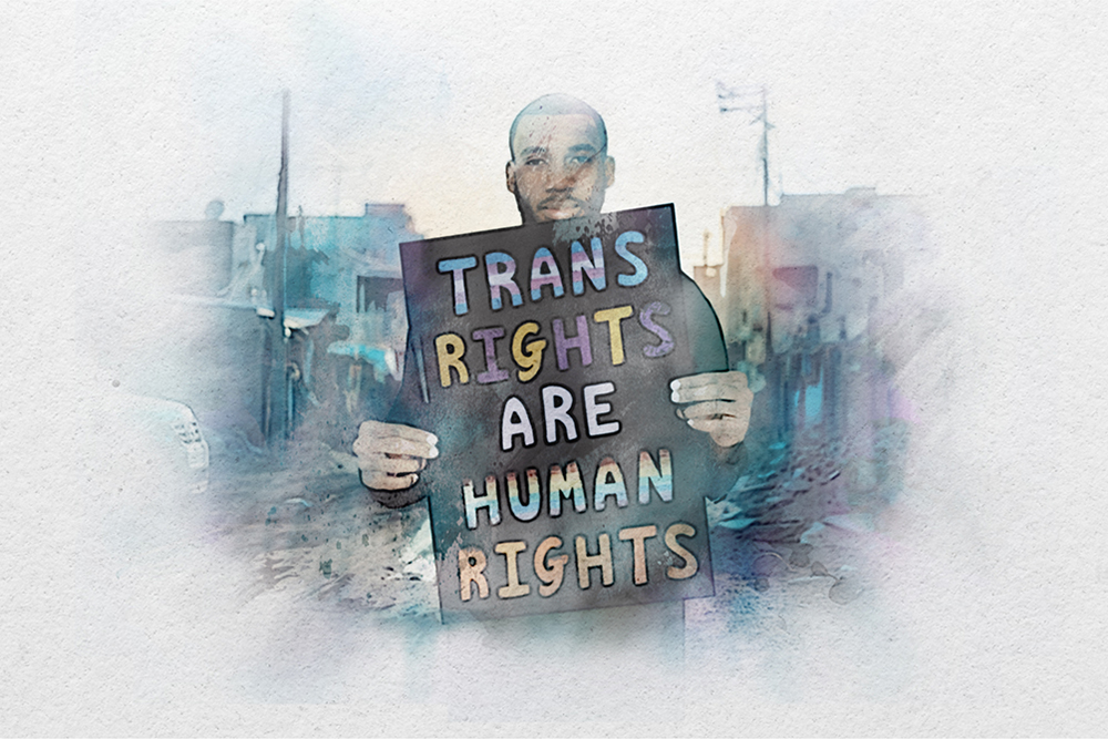 A person holds a sign that reads "Trans Rights Are Human Rights" against a blurred urban background.