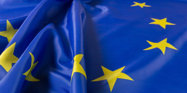 Close-up of a crumpled European Union flag, showing several yellow stars on a blue background.